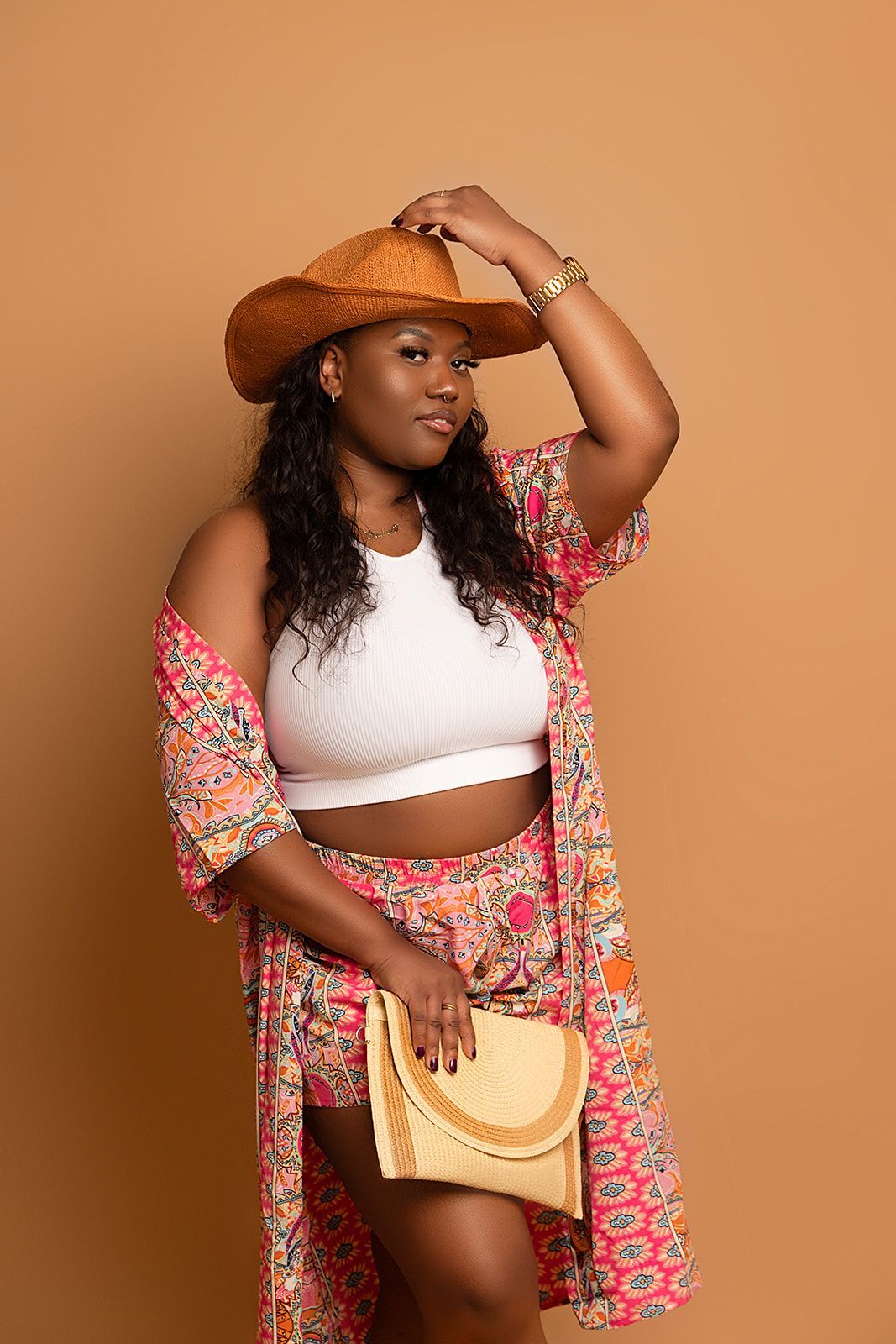 A woman is wearing a cowboy hat and holding a purse