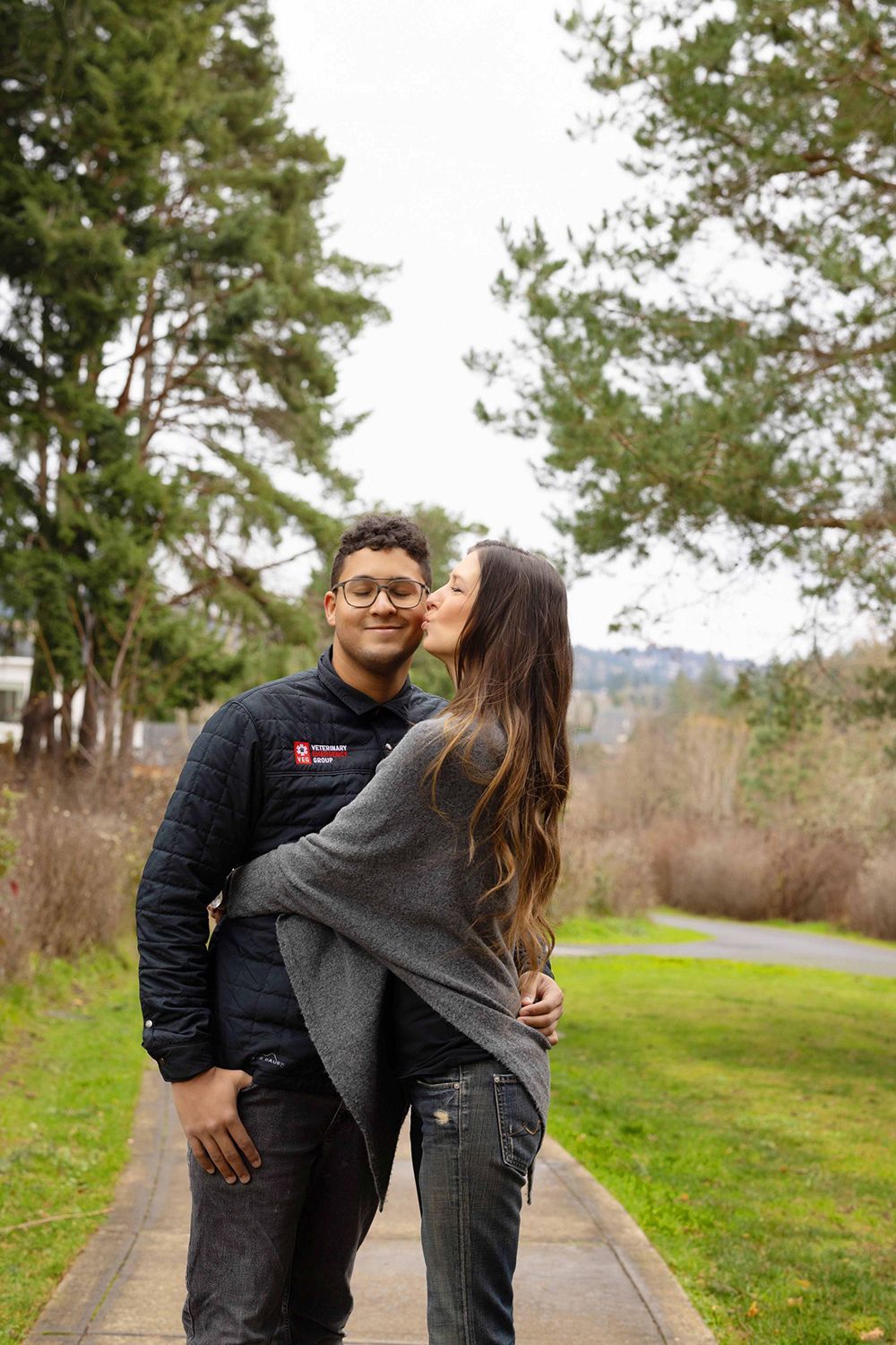 A woman kissing a guy on the cheek