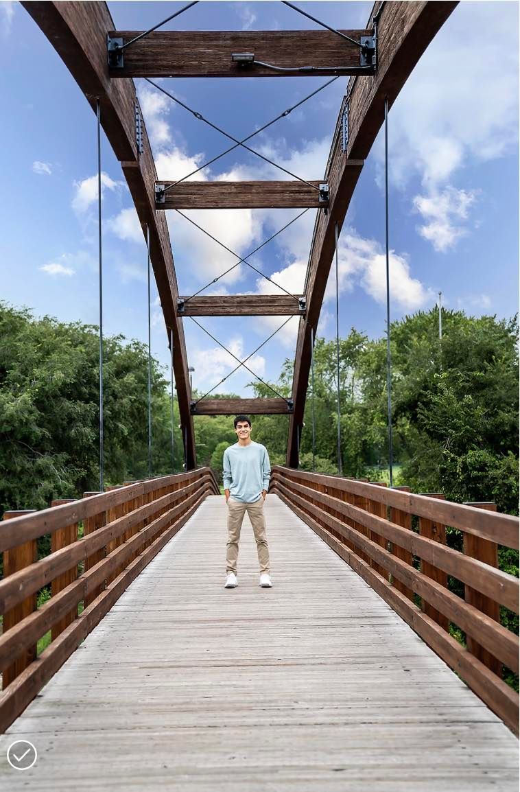 A man is standing on a wooden bridge