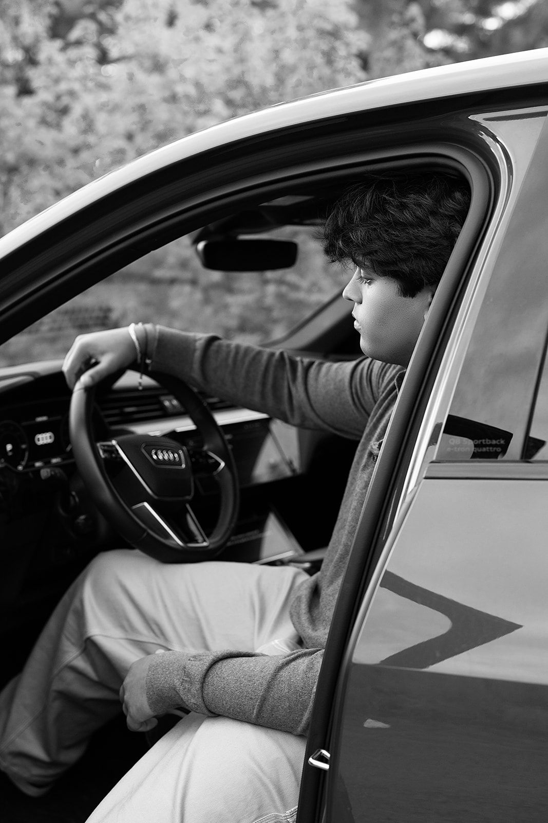 A man is sitting in the driver 's seat of a car.