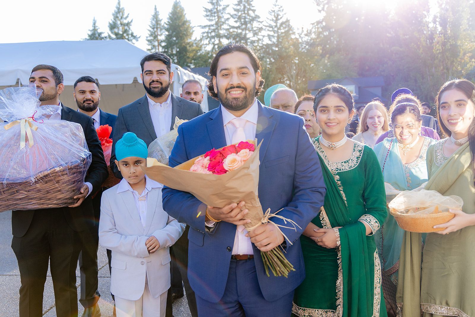 A man in a suit is holding a bouquet of flowers in front of a group of people