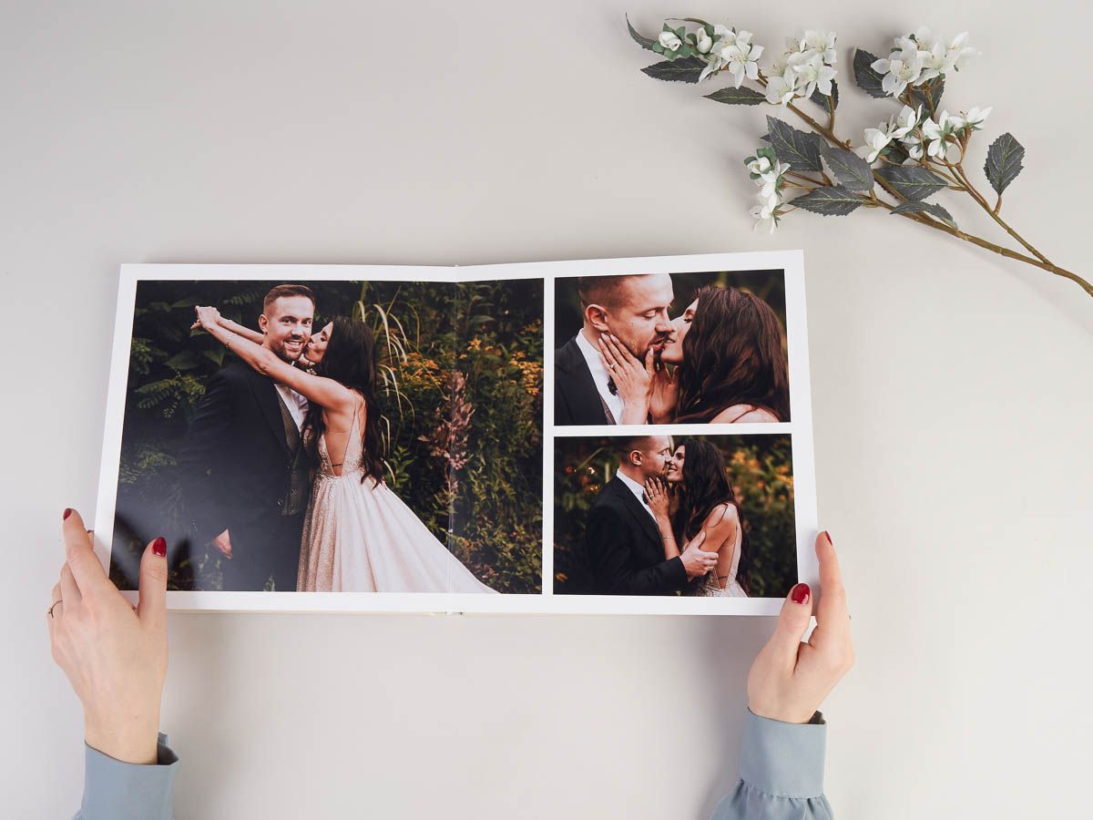 A person is holding a photo album with a bride and groom on it