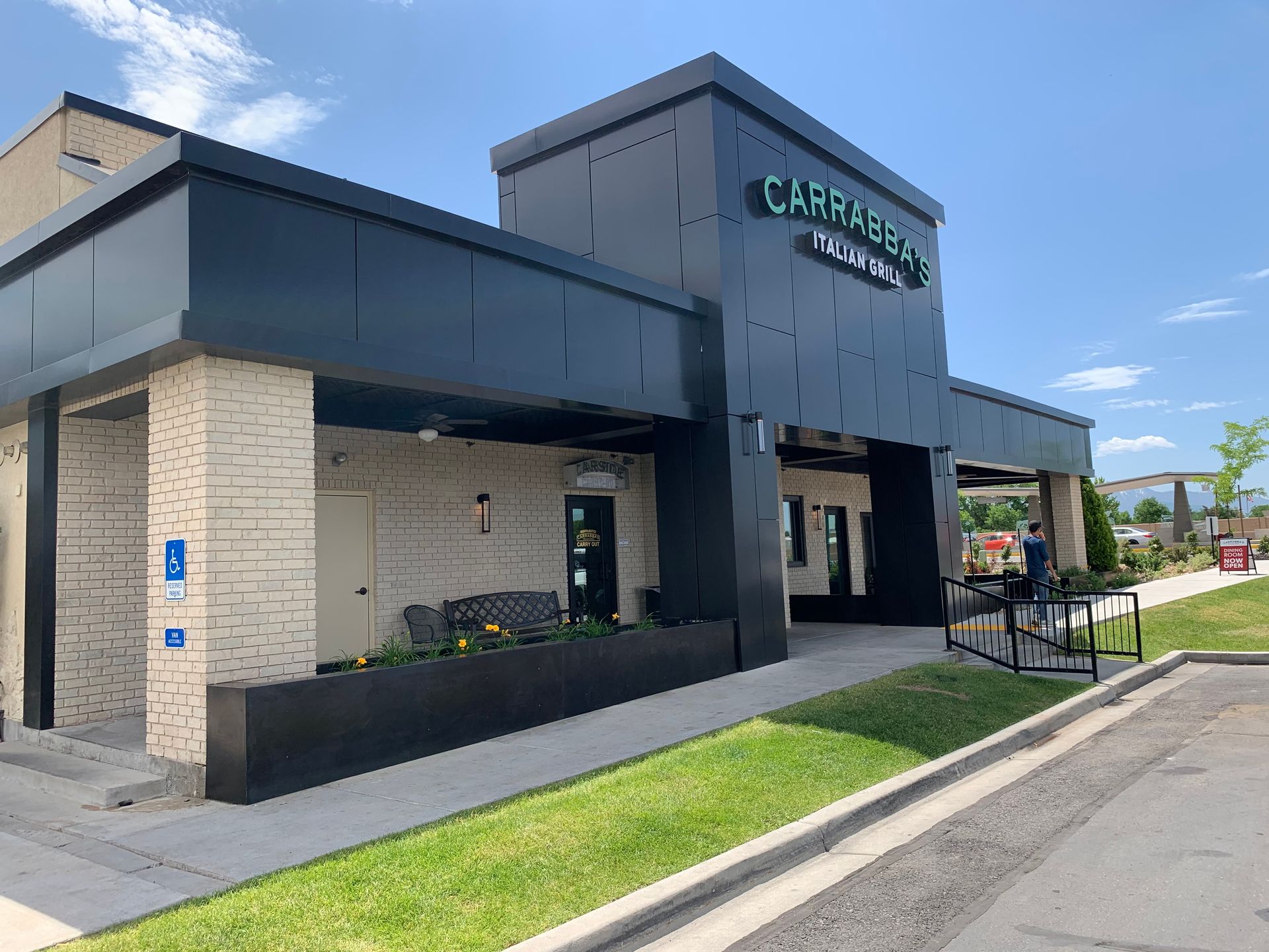 Exterior of Casareccio Italian restaurant, dark exterior with green sign, sidewalk.