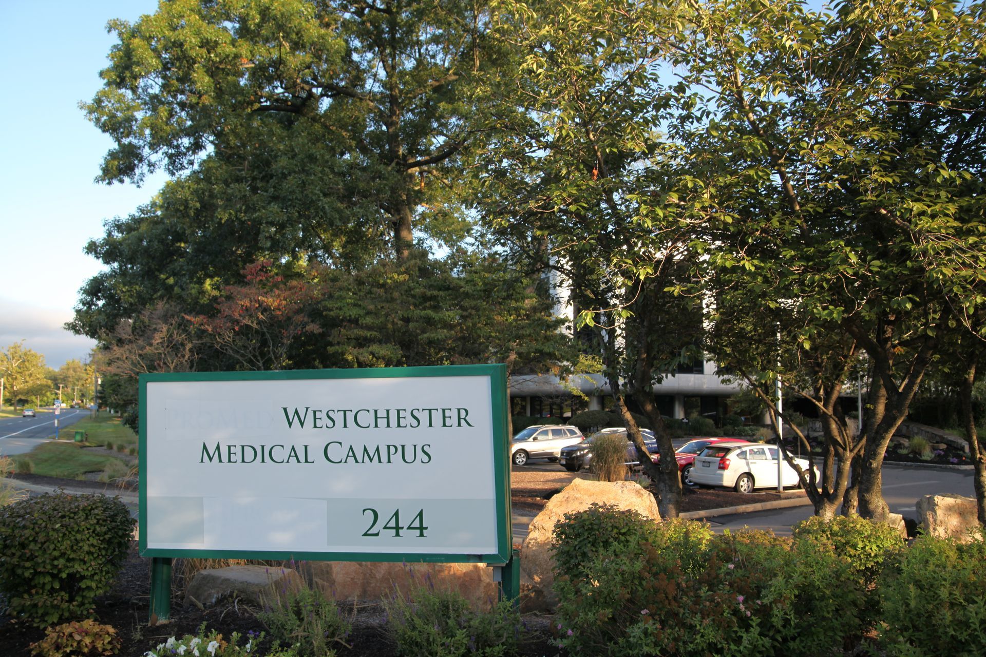 large rocks forming a retaining wall with green grass and mulch bed above