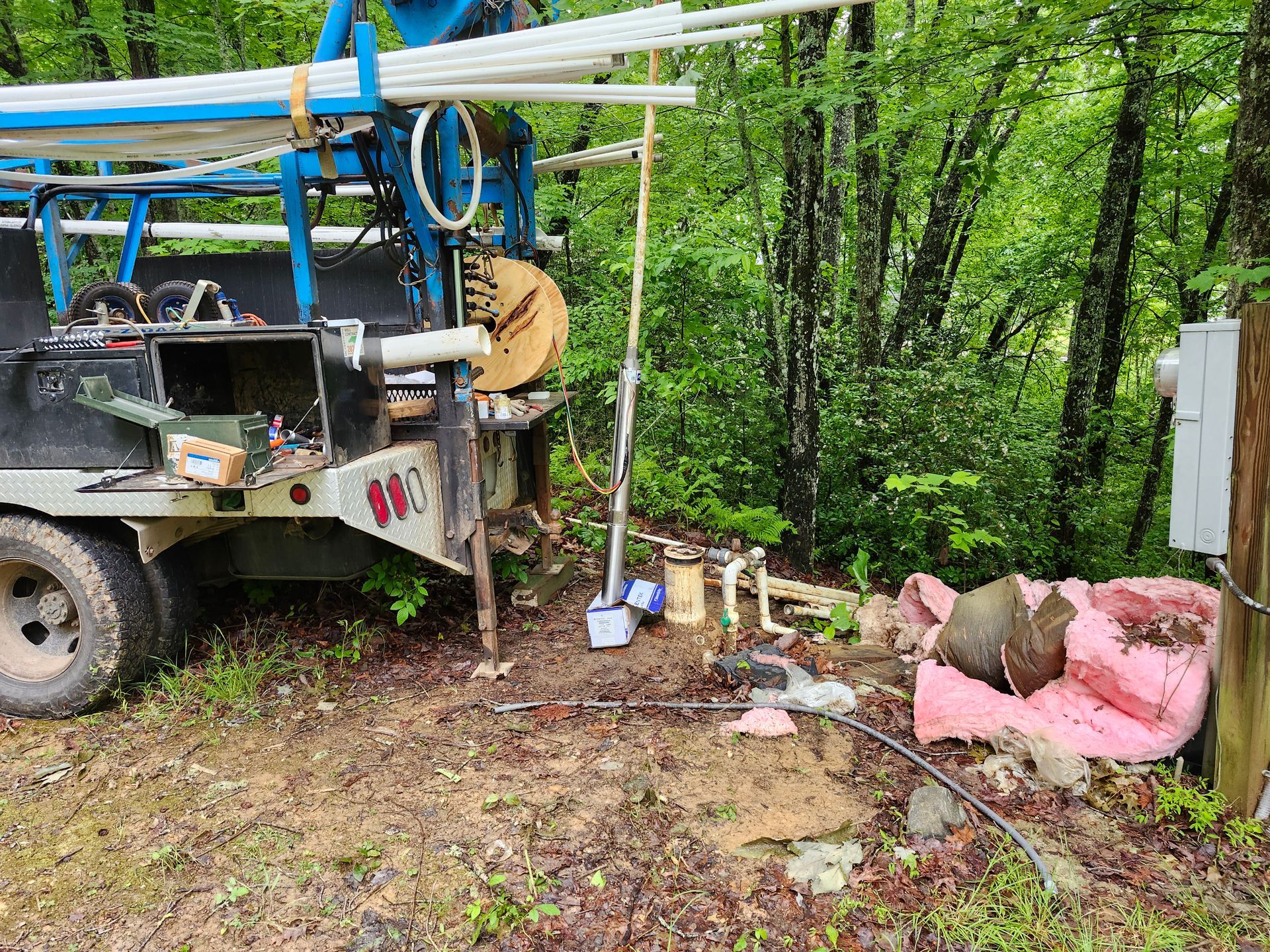 A truck is parked on the side of the road in the woods