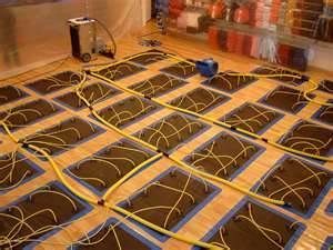Floor drying system with mats, tubes, and a dehumidifier in a room.