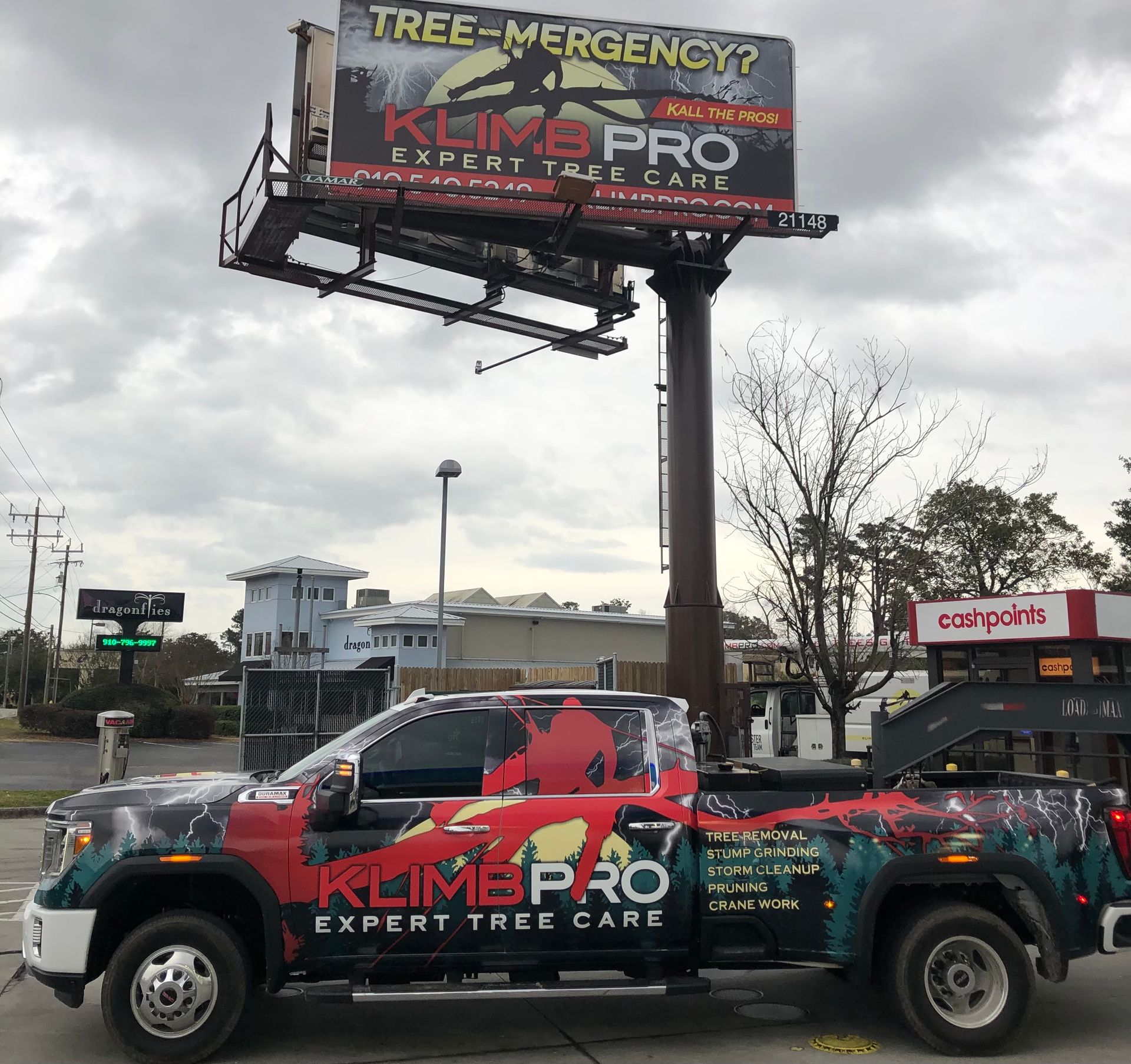 A truck is parked in front of a billboard for klimapro