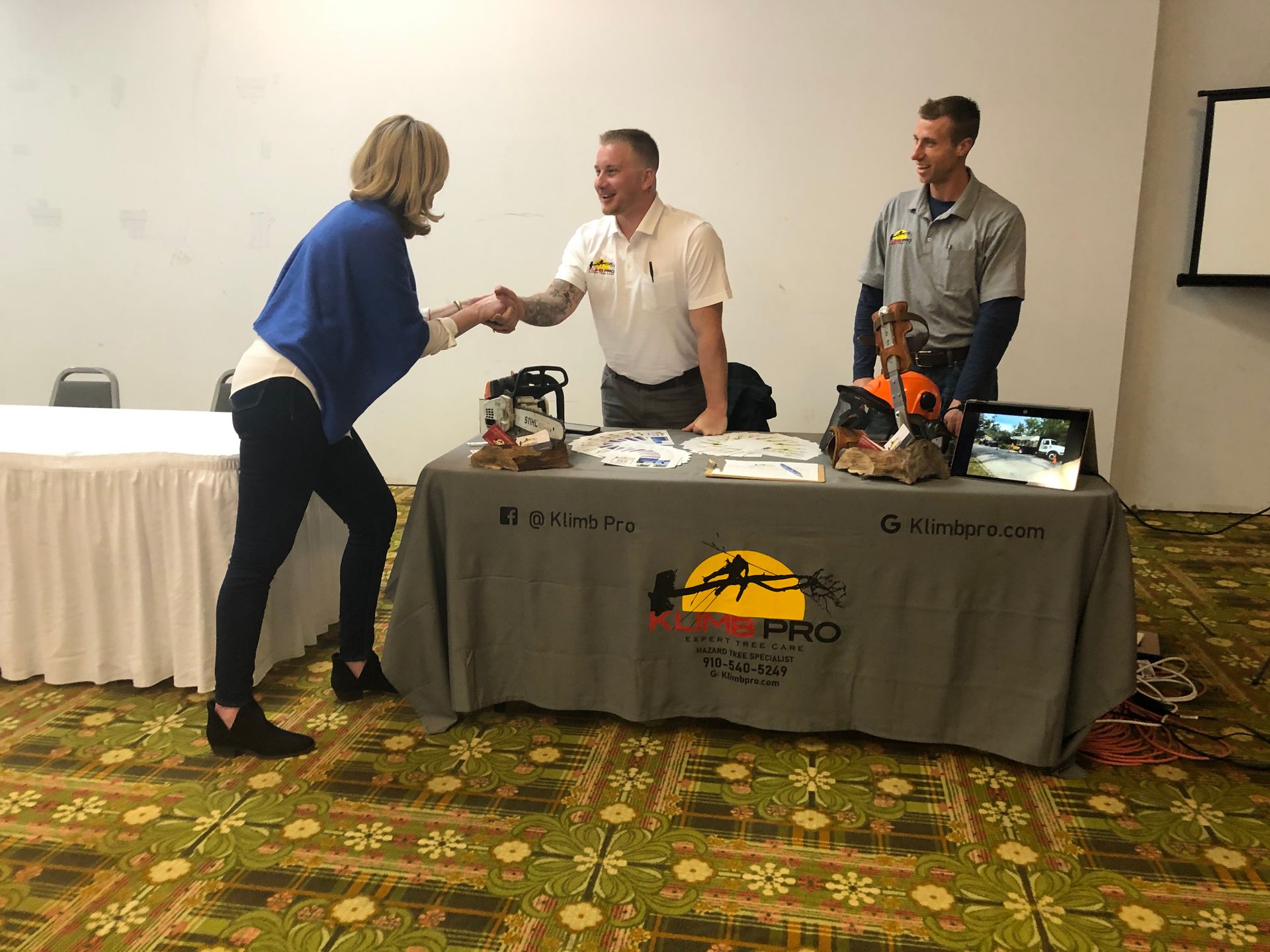 A woman is shaking hands with a man at a table.