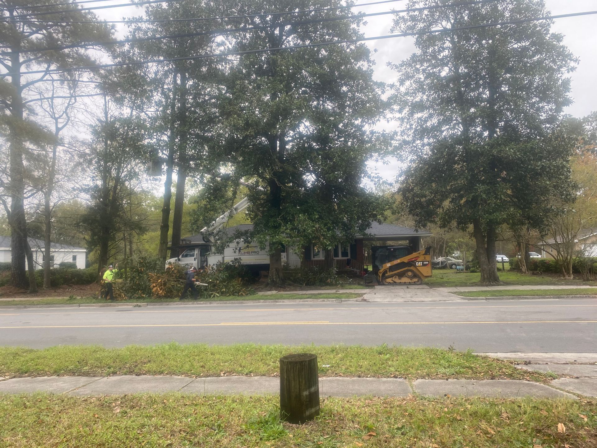 A house is sitting on the side of the road next to a tree.