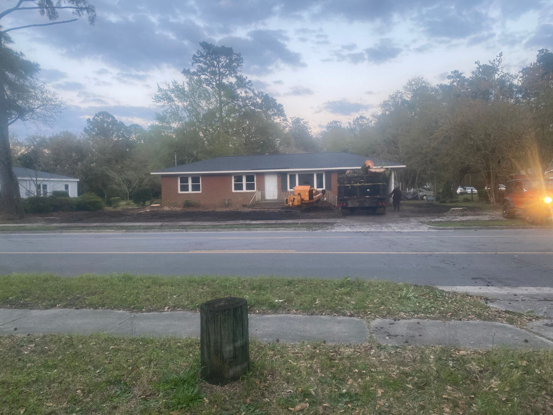 A house is sitting on the side of the road next to a road.