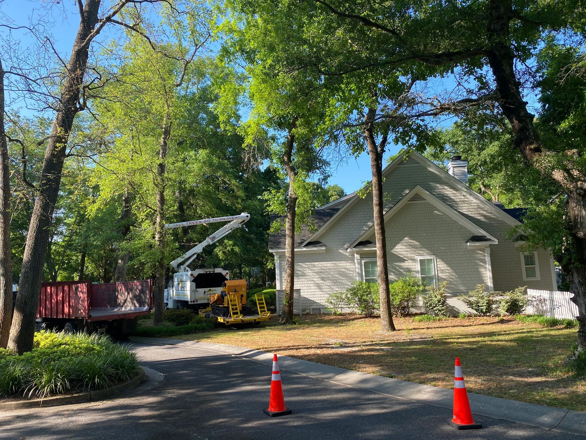 A tree cutting truck is parked in front of a house.