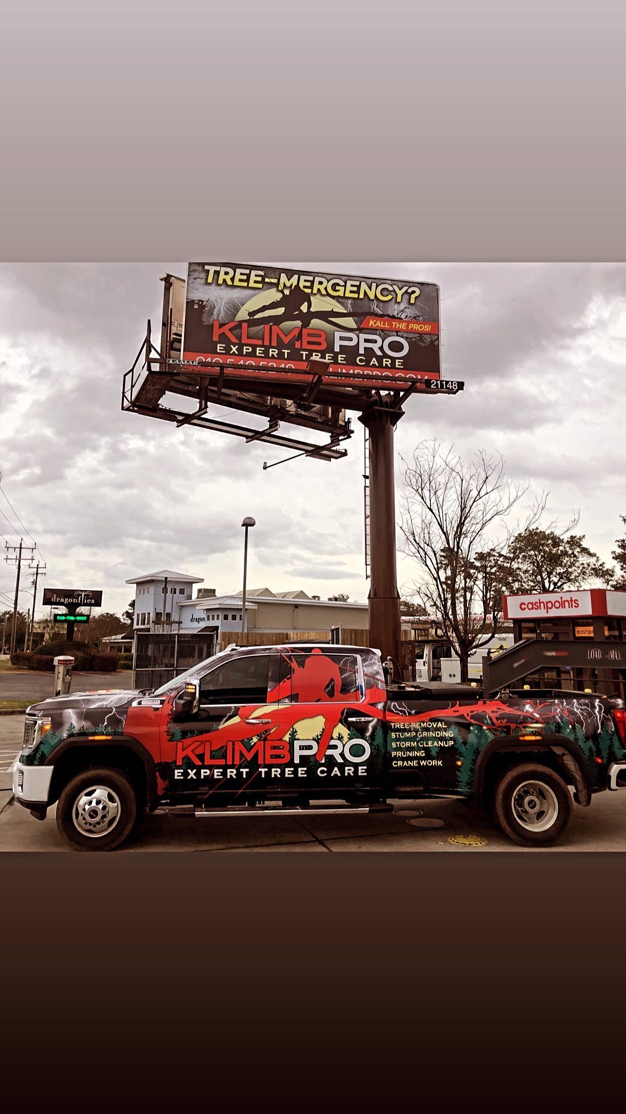 A truck is parked in front of a large billboard.