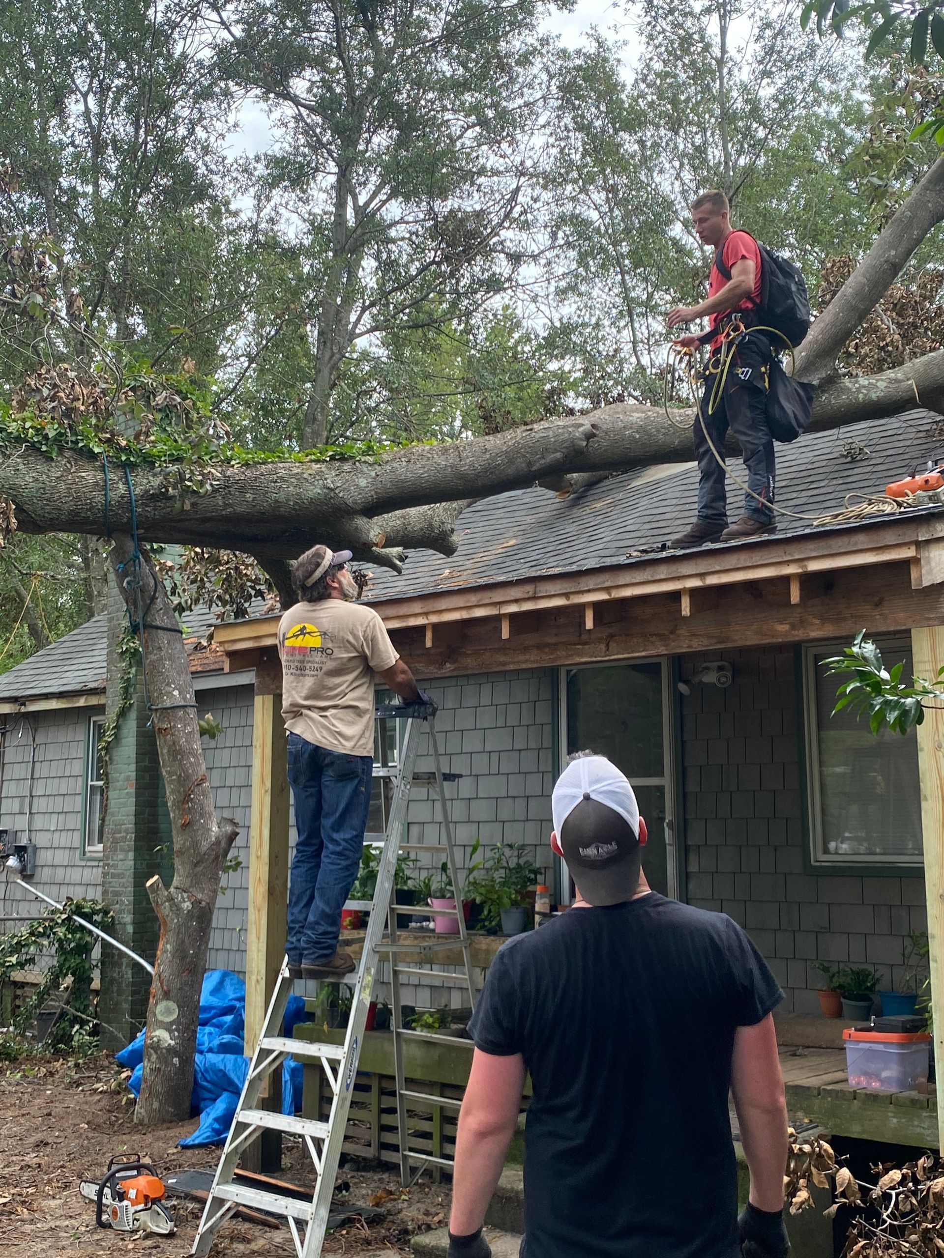Two men are working on the roof of a house.