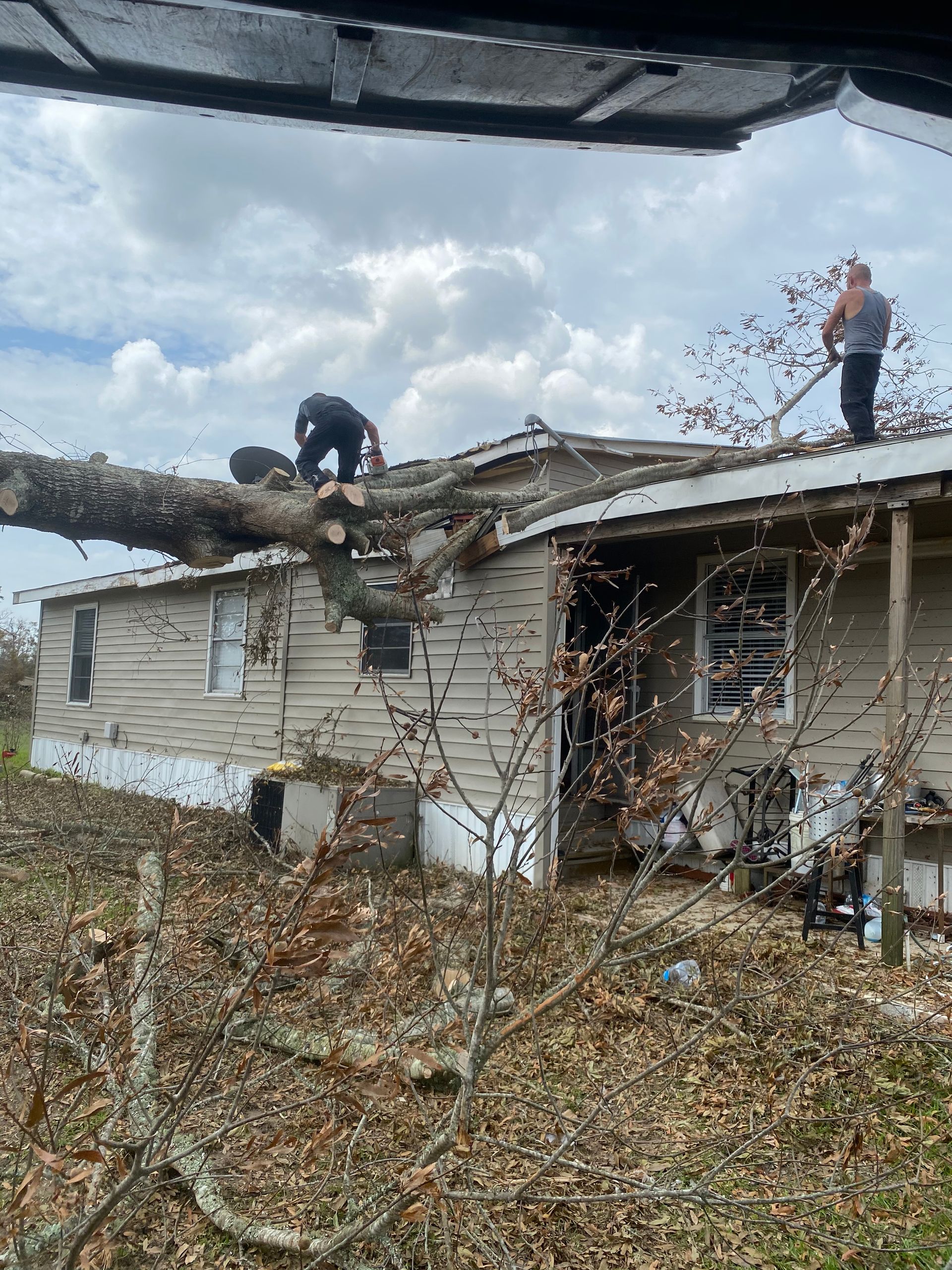 Two men are working on the roof of a mobile home.