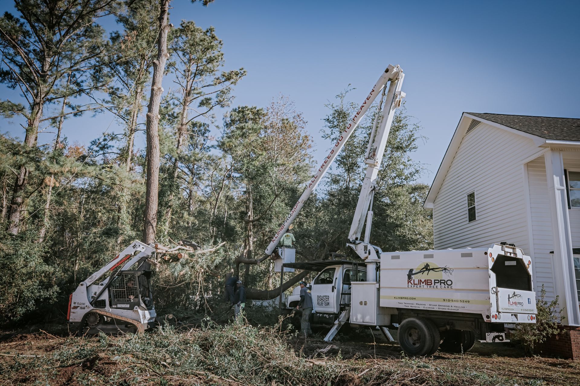 A tree cutting truck is parked in front of a house.