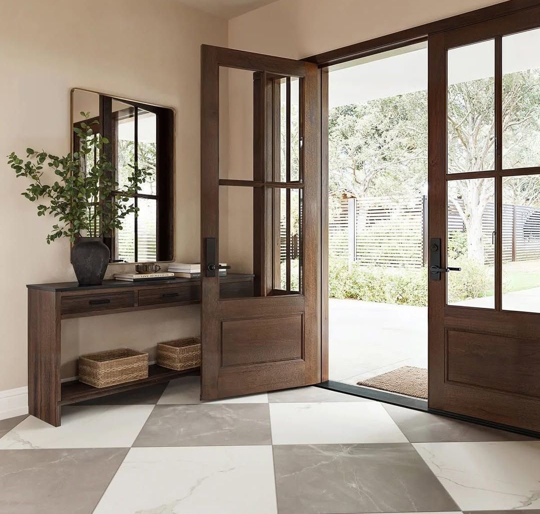 Entryway with open wooden doors, a console table, and checkered floor.
