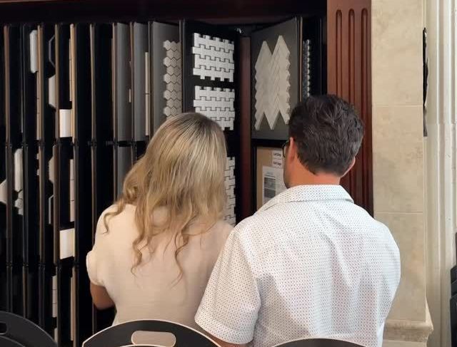 Couple looking at tile samples in a showroom, choosing materials for a project.
