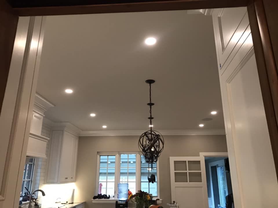 A kitchen with white cabinets and a chandelier hanging from the ceiling