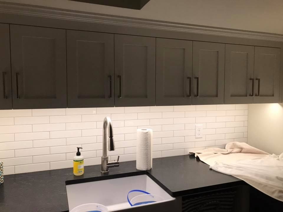 A kitchen with a sink and a soap dispenser