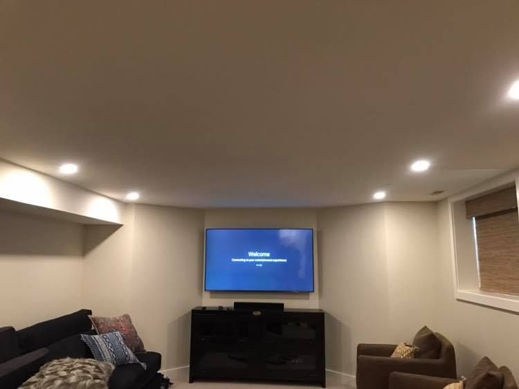 A living room with a flat screen tv on the wall.