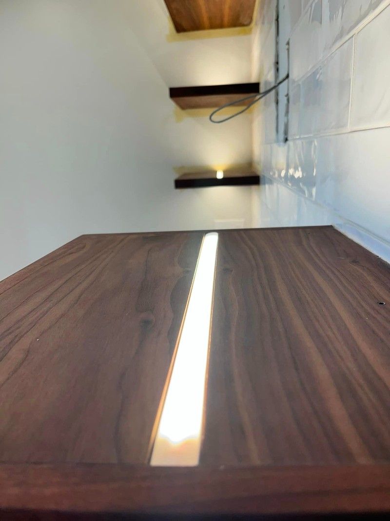 A wooden table with a light on it in a room.
