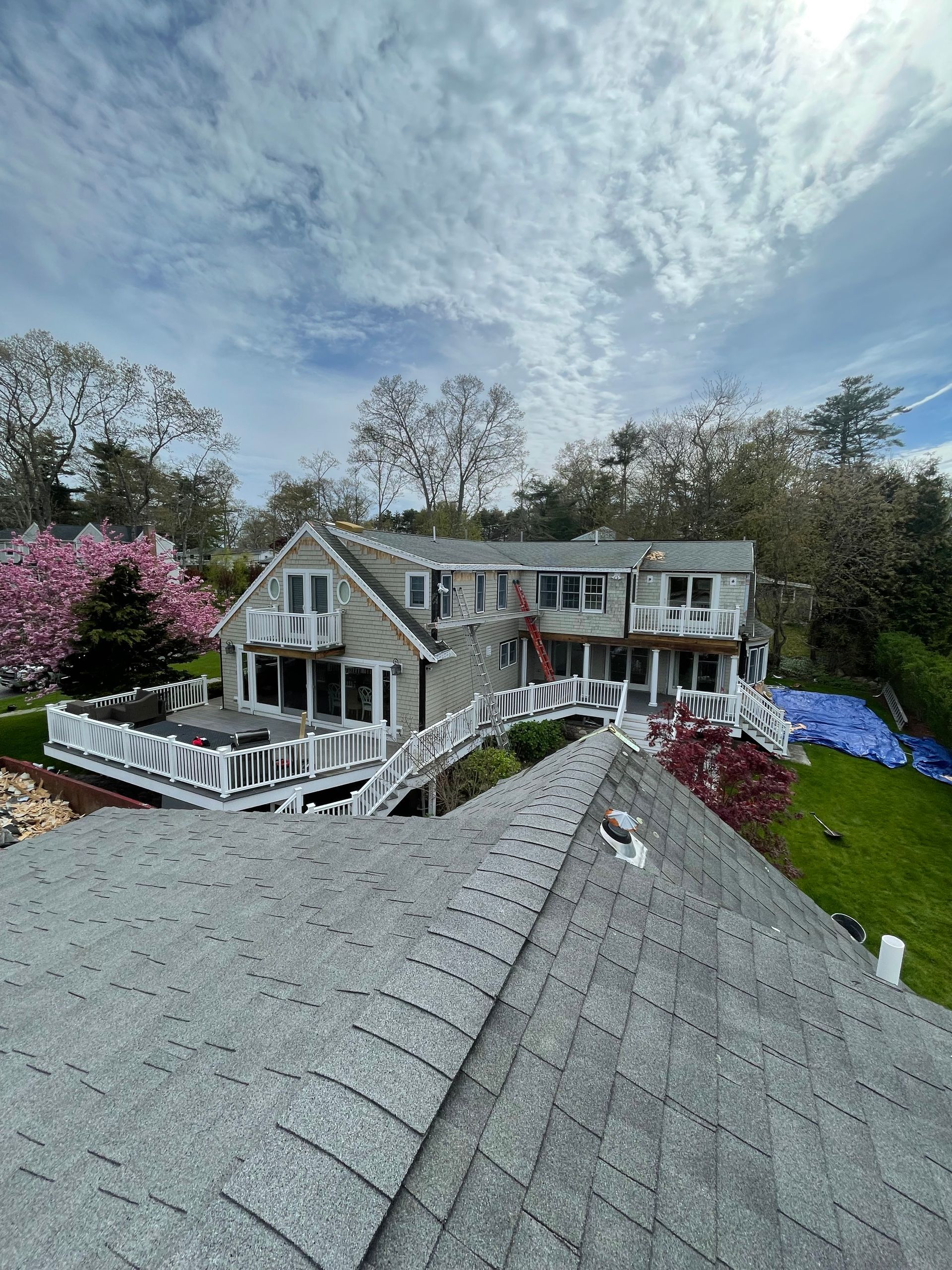 An aerial view of a large house with a roof and a deck