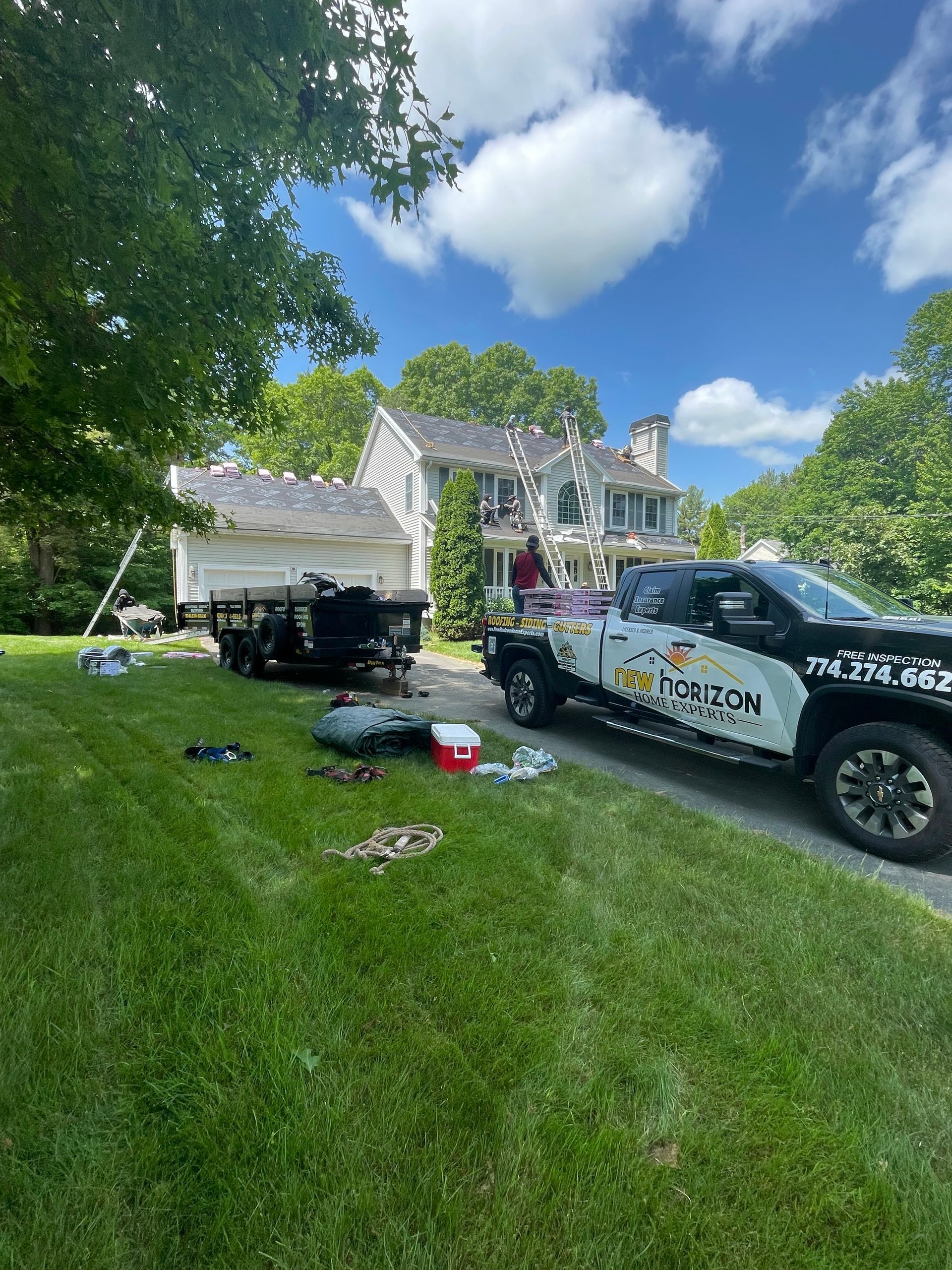 A truck is parked in front of a house with a trailer attached to it