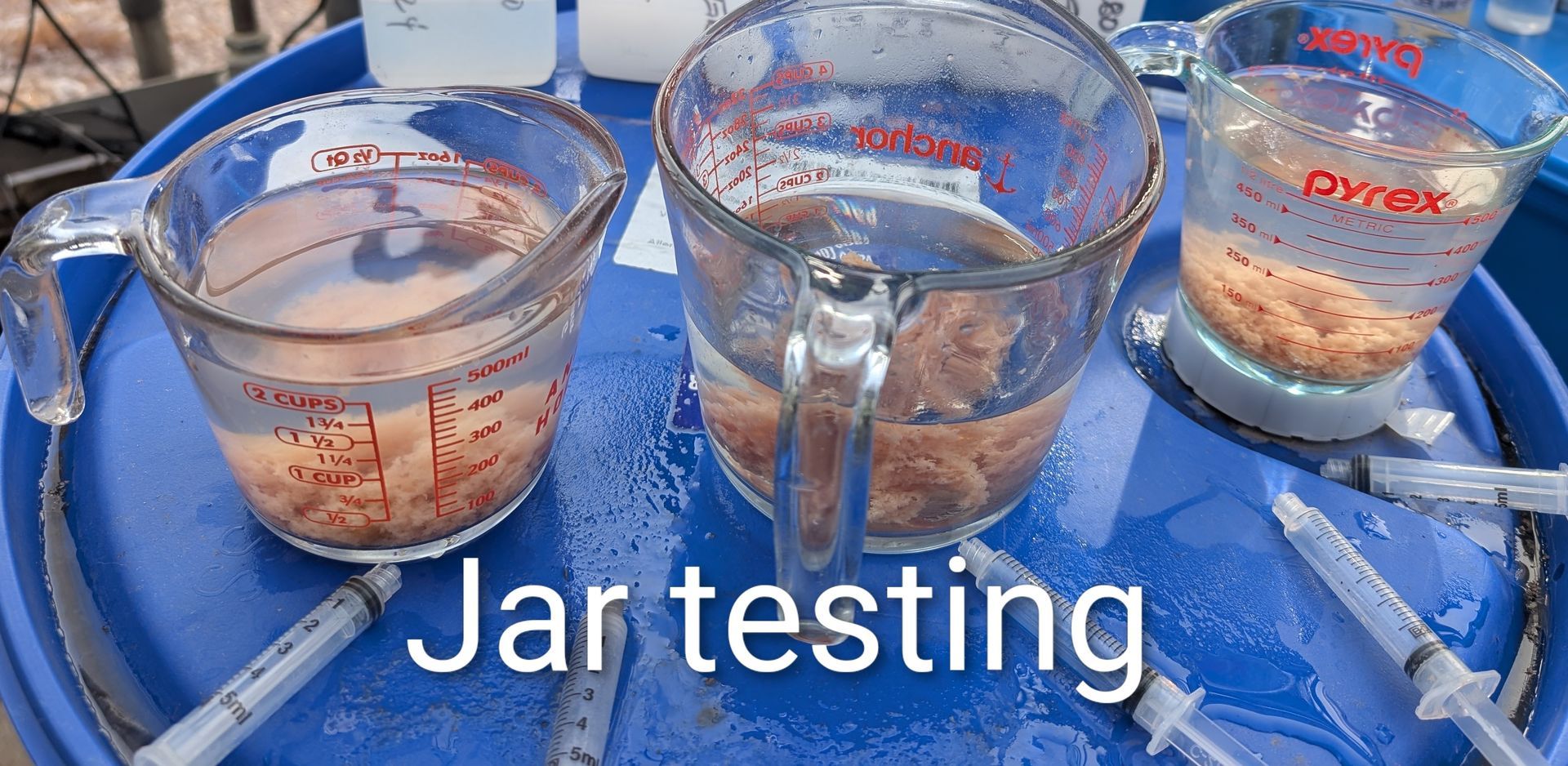 Blue water filtration tanks and pipes in an industrial basement.