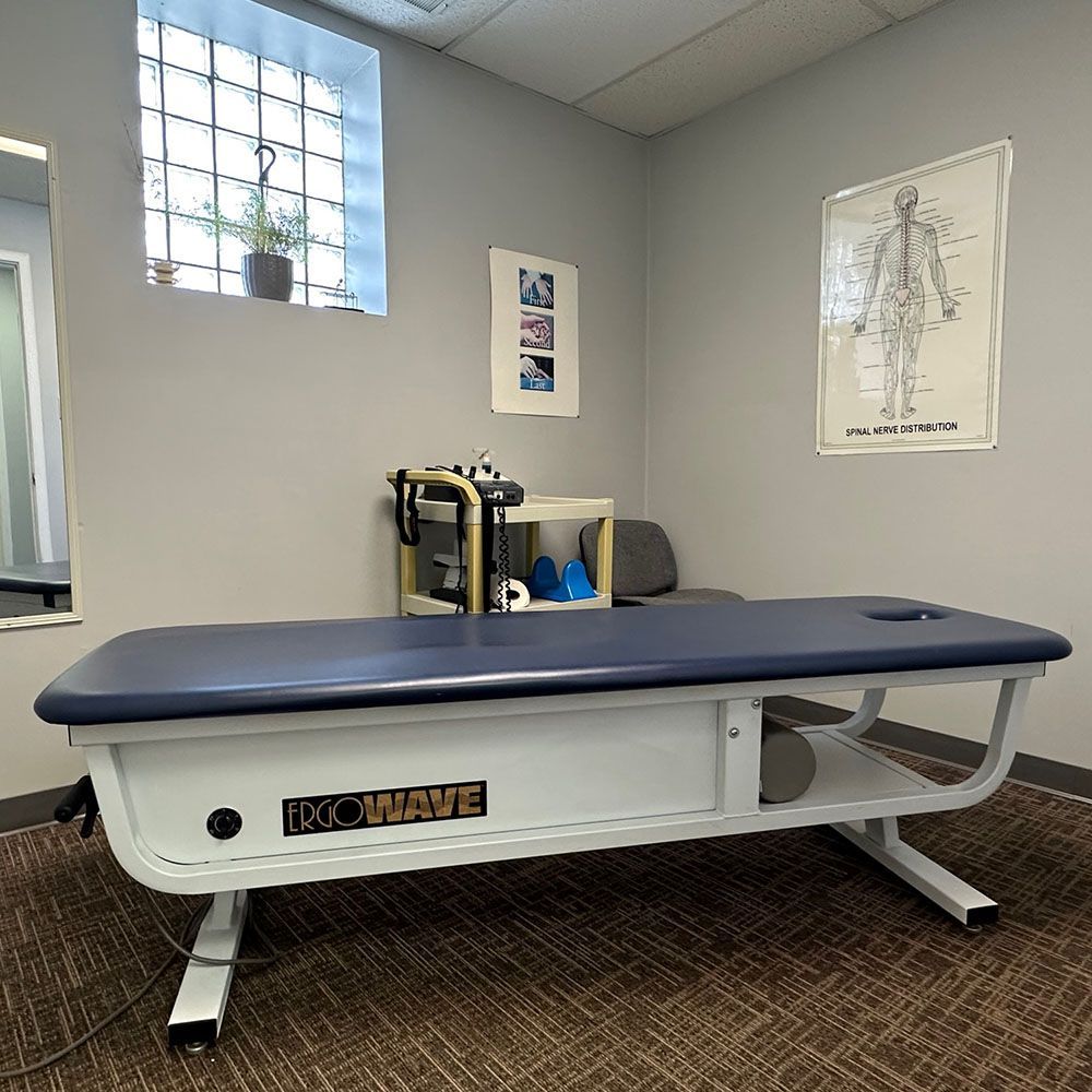 A therapy table is sitting in a room next to a window.