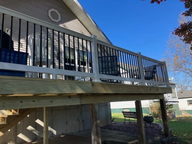 A wooden deck and stairs with black and white railings