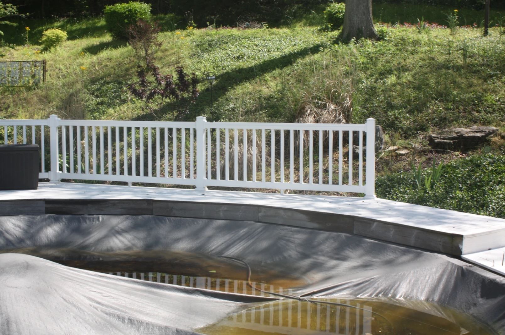 A pond with a white fence surrounding it