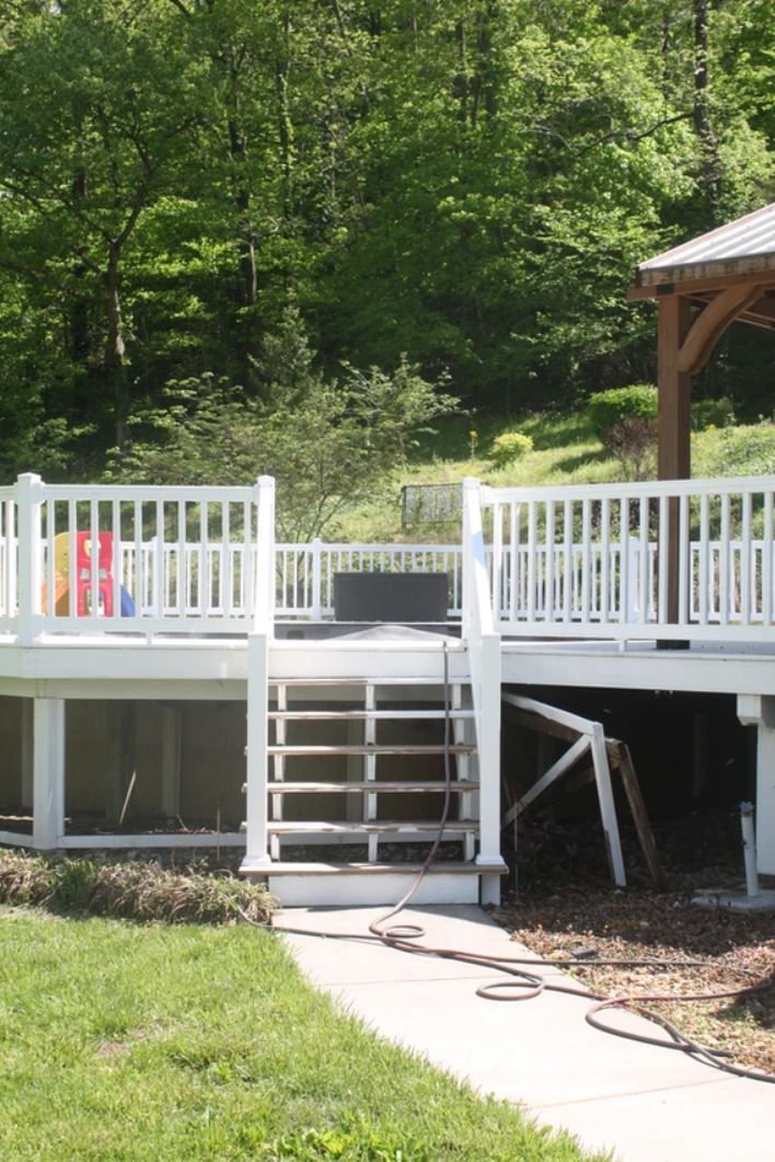 A large white deck with a gazebo in the background.