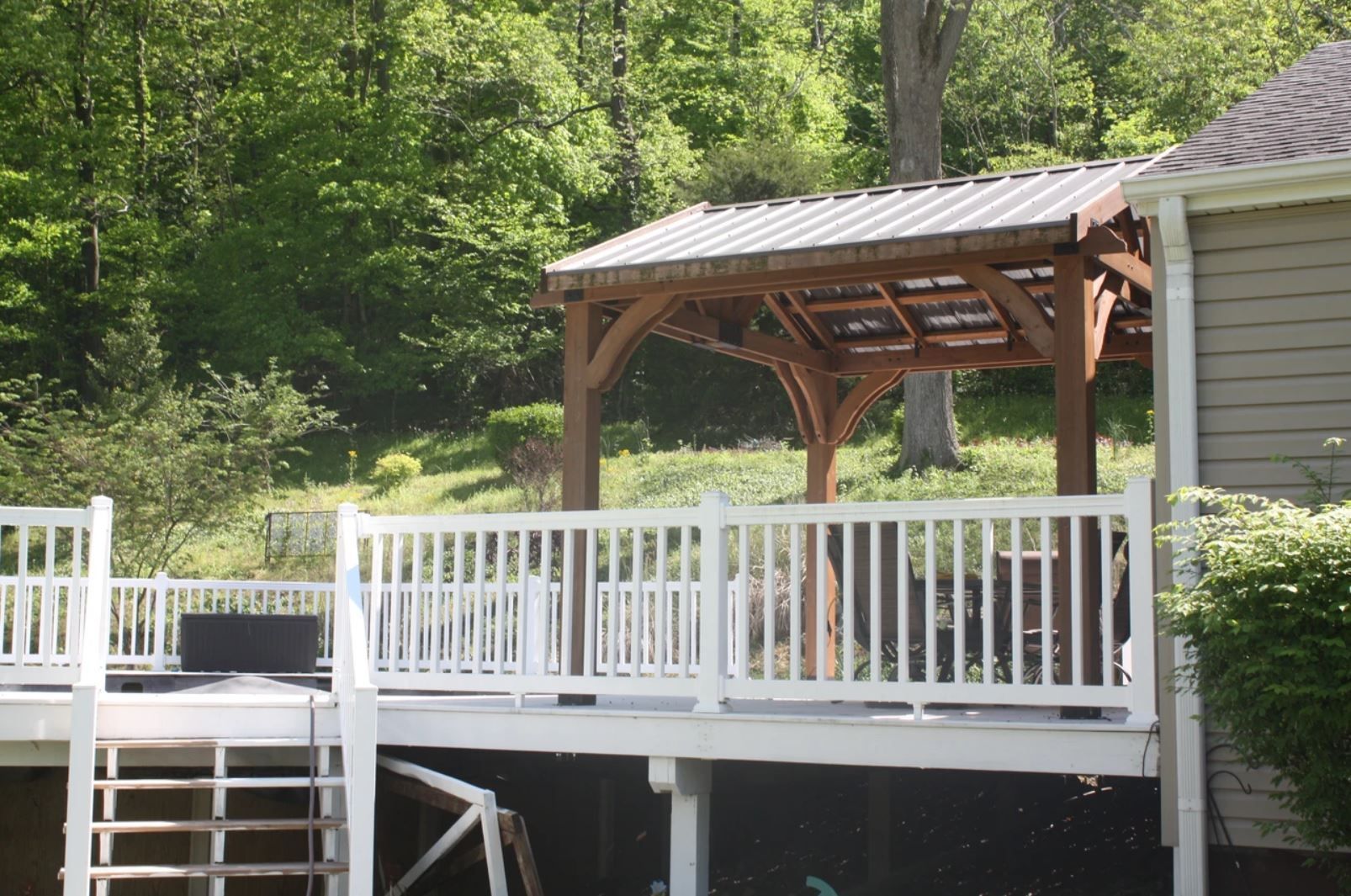 A white deck with a wooden gazebo on top of it
