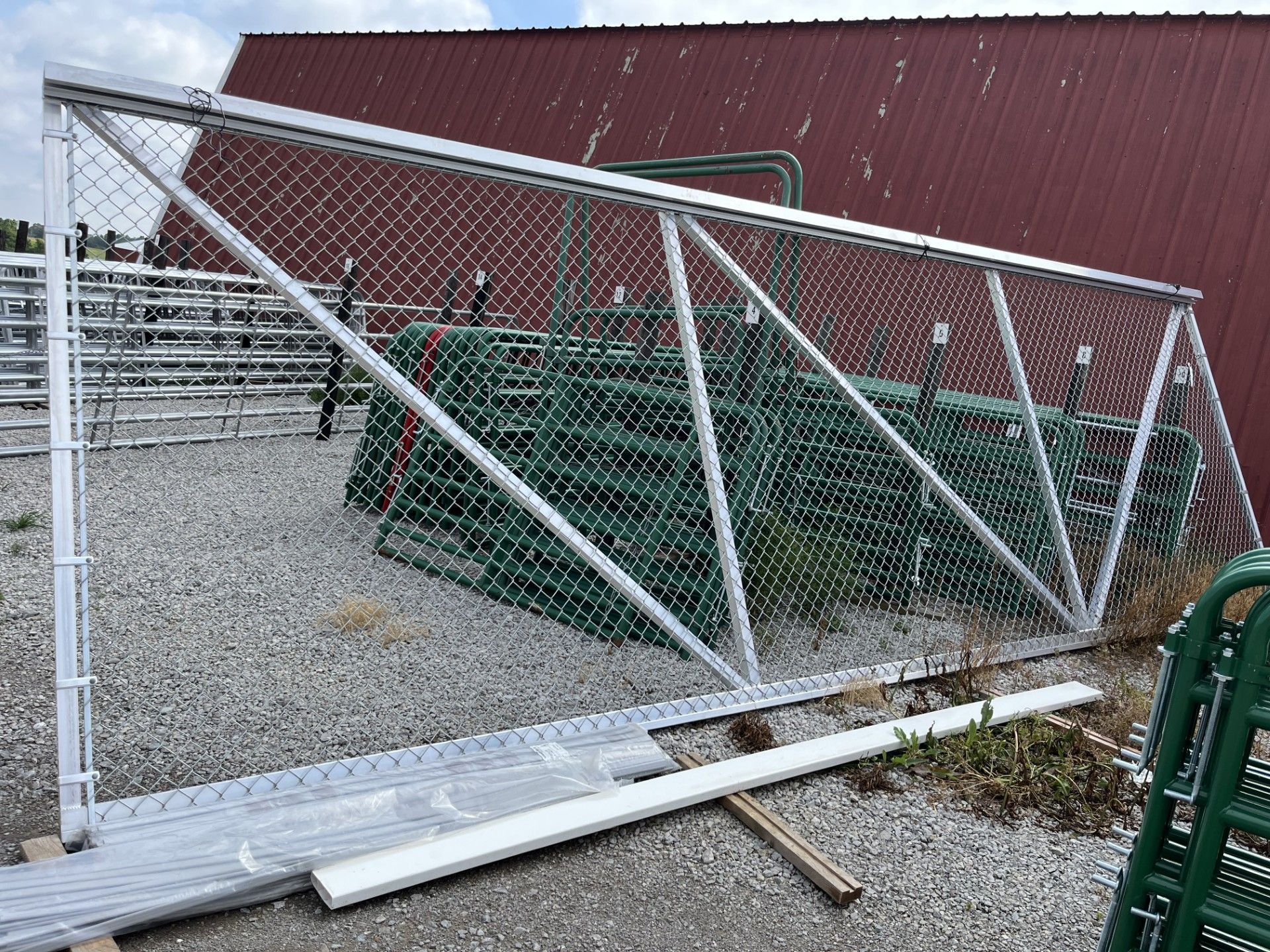 A chain link fence is sitting on the ground in front of a building.