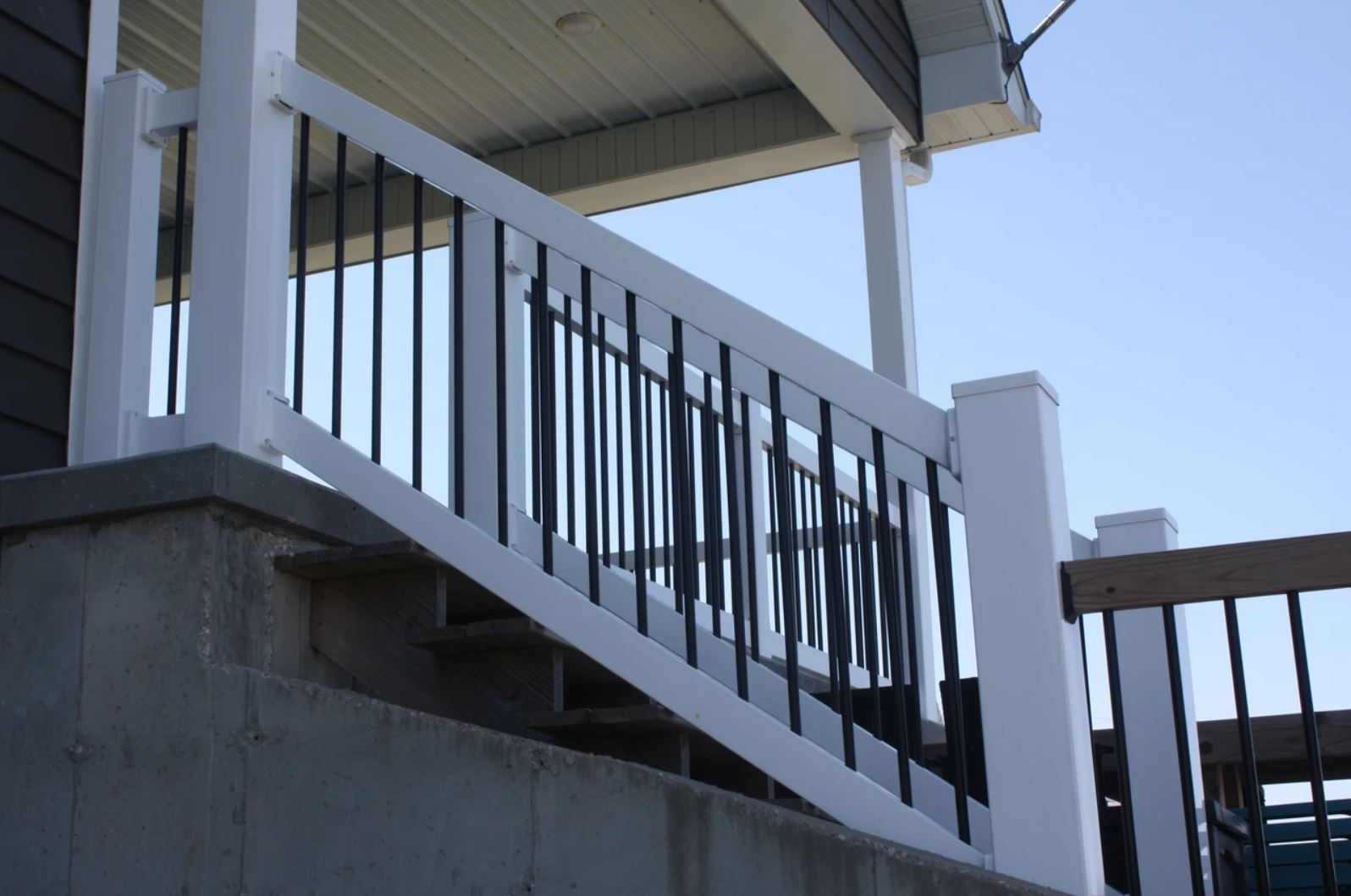 A white railing with black bars on a set of stairs