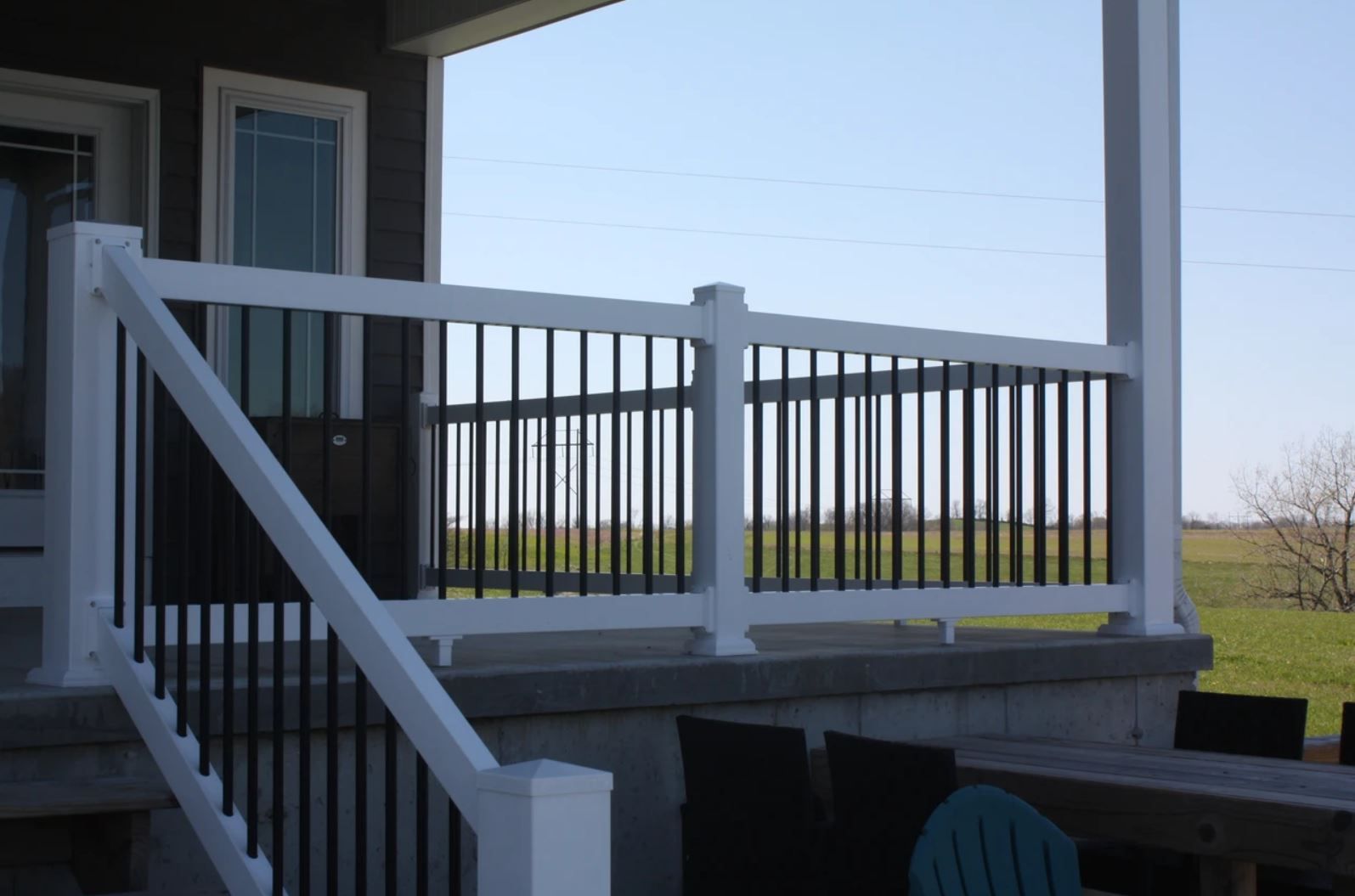A porch with a white railing and black bars