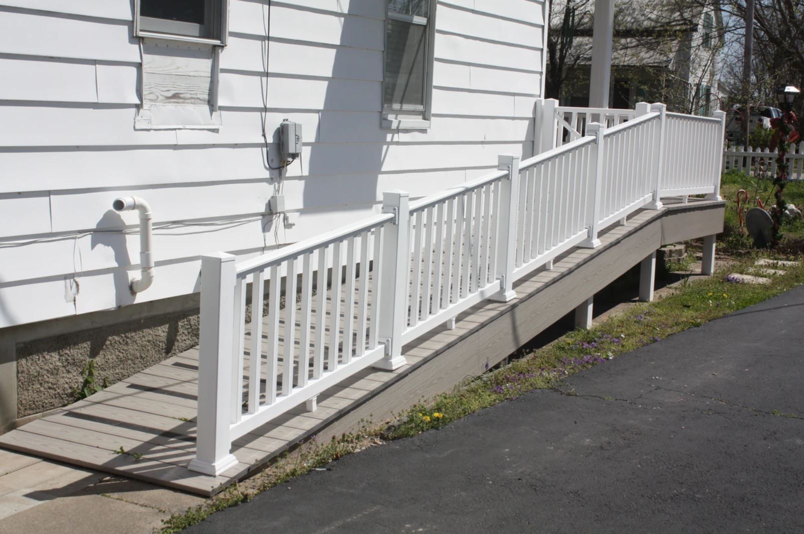 A white house with a ramp and a white railing