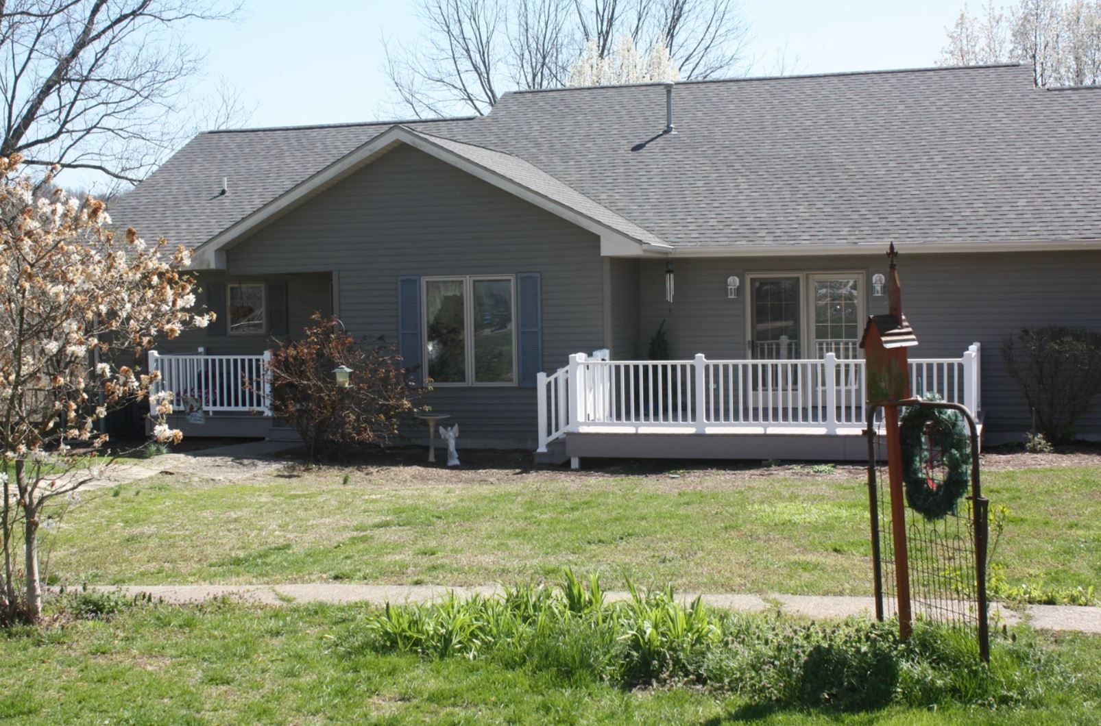 A house with a white railing and a wreath in front of it