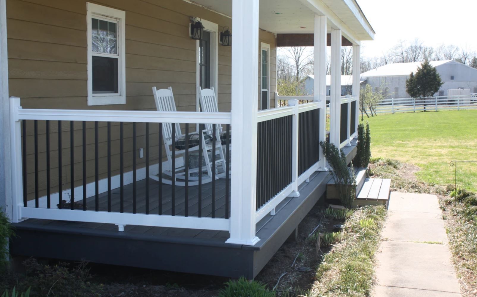 There is a porch with a table and chairs on it.