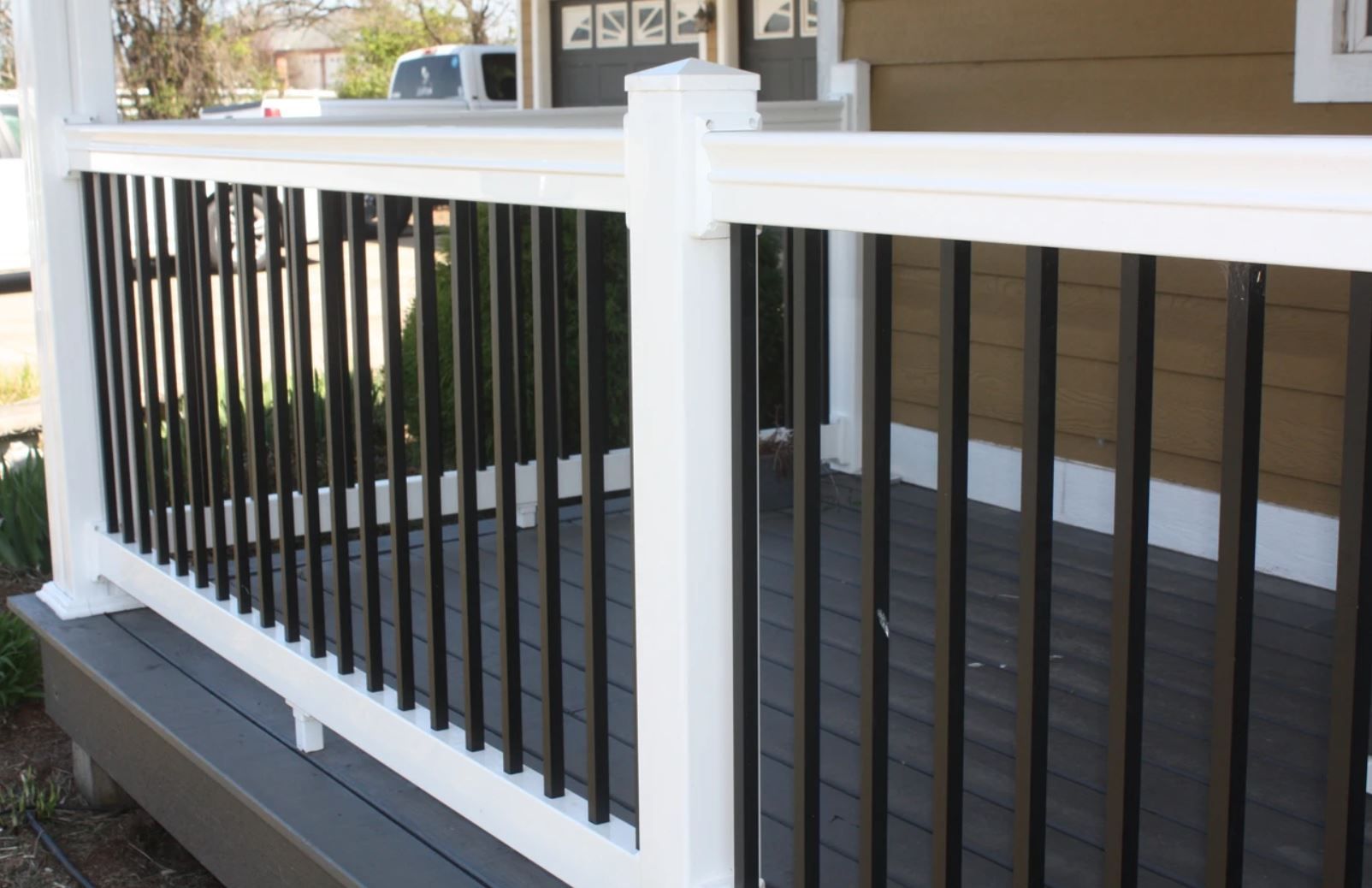 A porch with a white railing and black bars