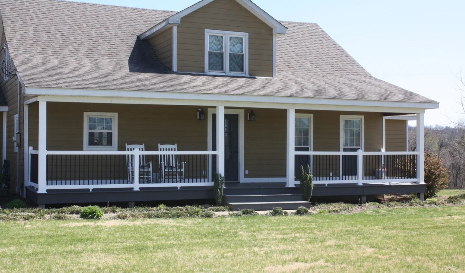 A large brown house with a large porch