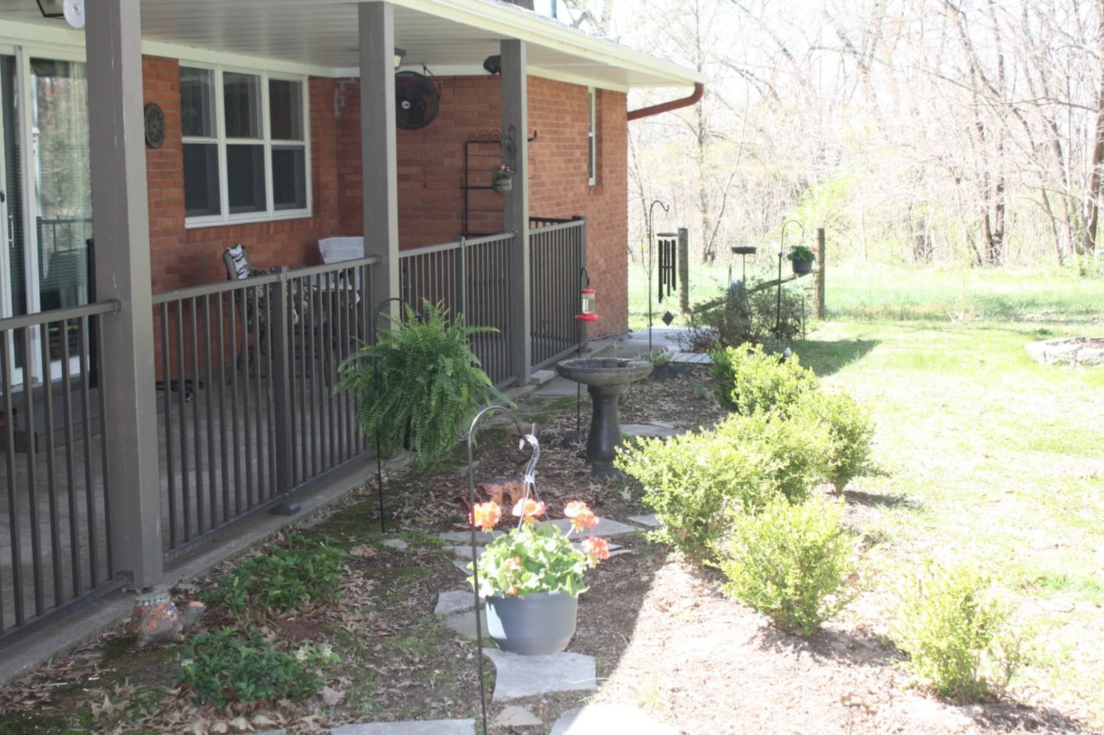 A brick house with a porch and a fence