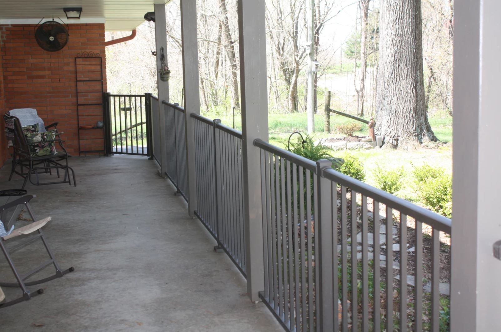 A porch with a metal railing and rocking chairs