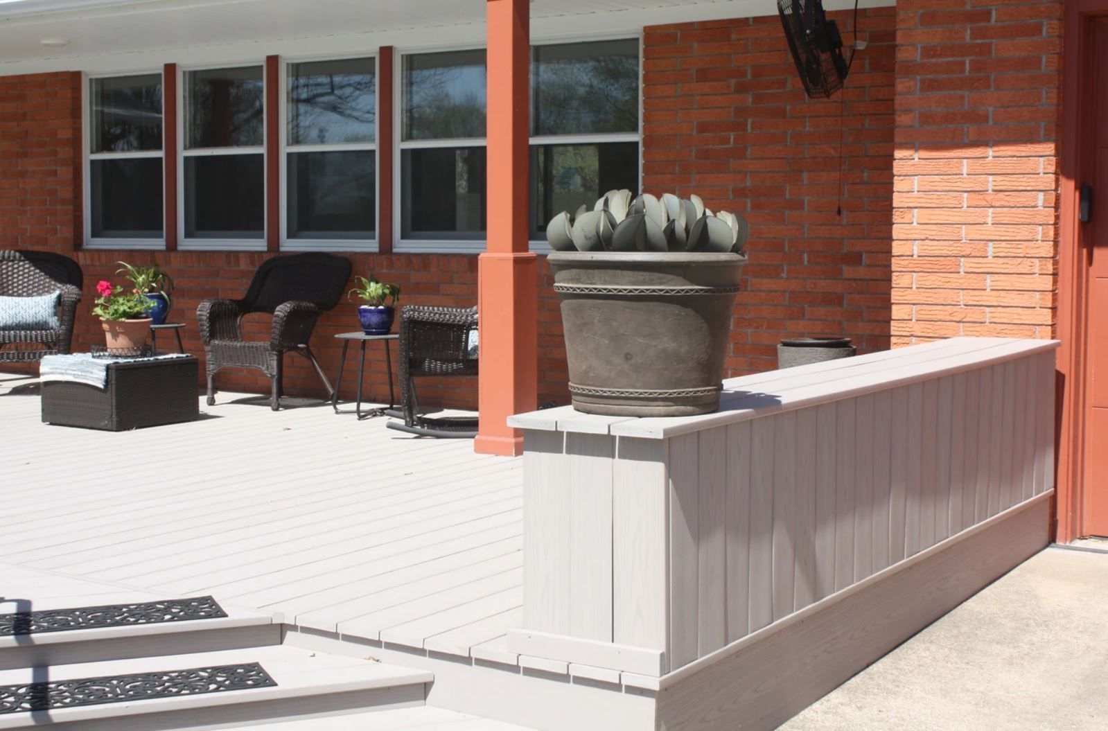 A potted plant sits on the side of a brick house
