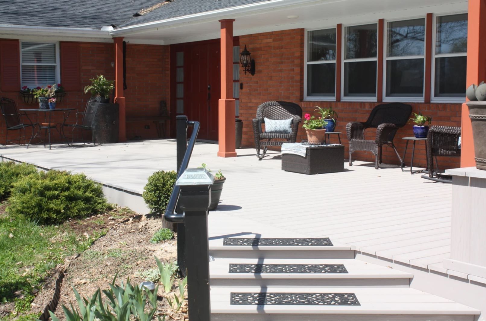A brick house with a patio and stairs leading to it