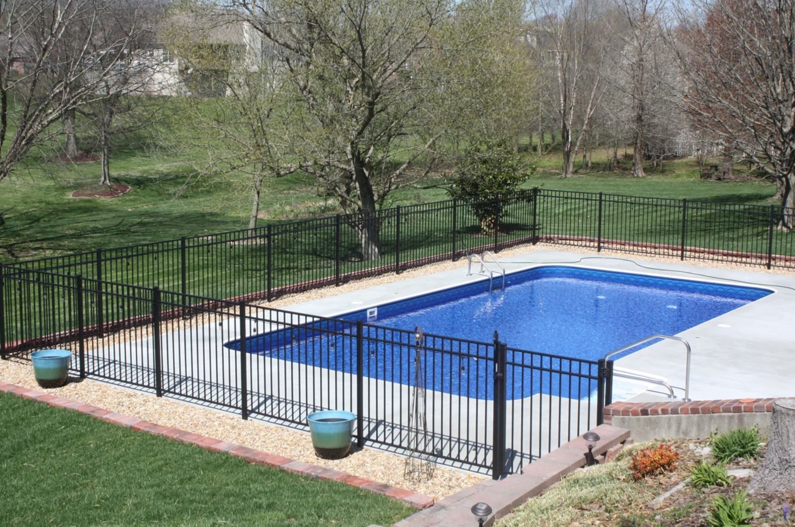A large swimming pool surrounded by a black fence