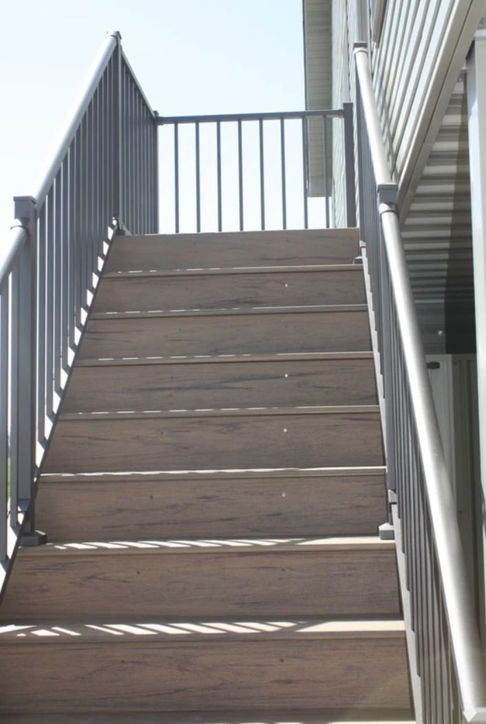 A set of wooden stairs with a metal railing