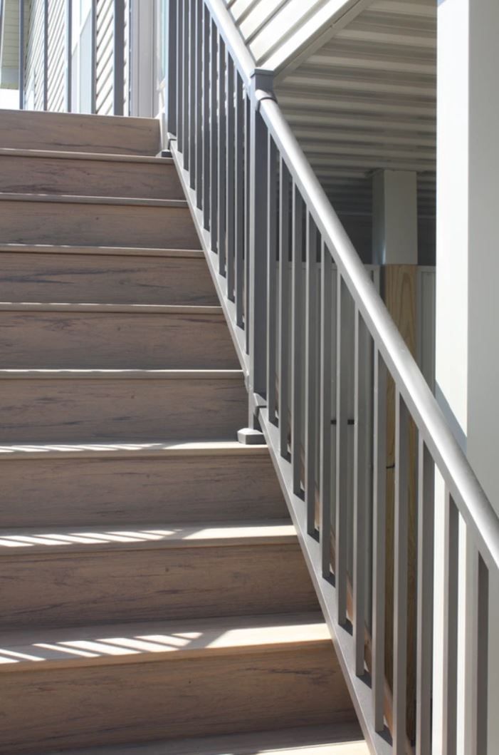 A set of wooden stairs with a metal railing