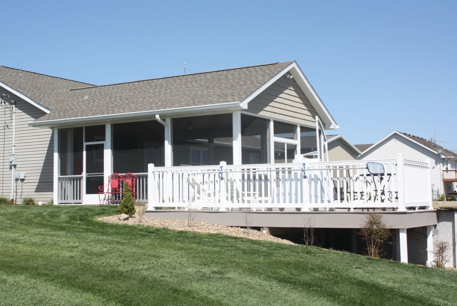 A house with a screened in porch and a white railing
