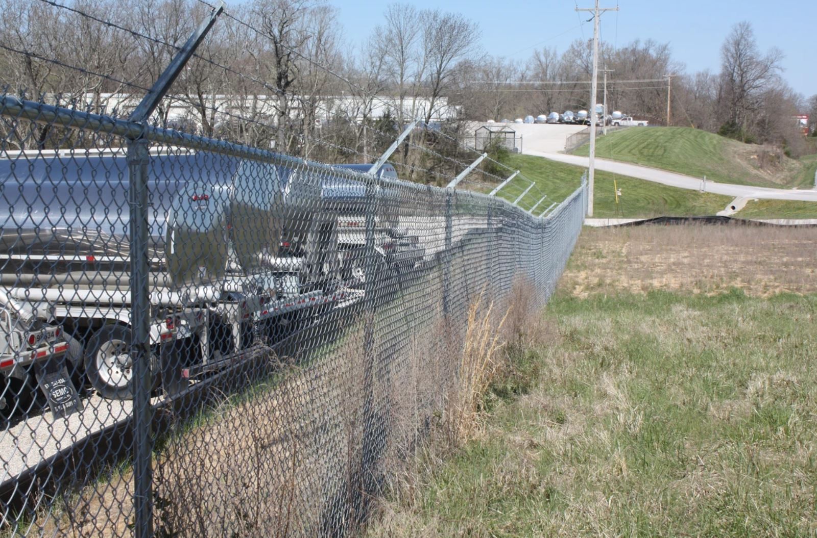 A chain link fence with barbed wire on top of it